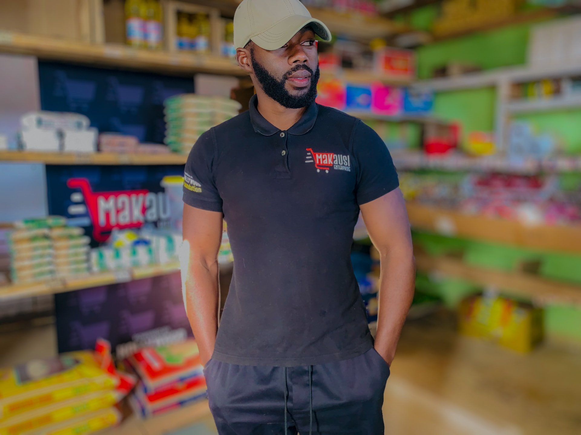 The Makausi Enterprise director in a branded shirt standing inside the store